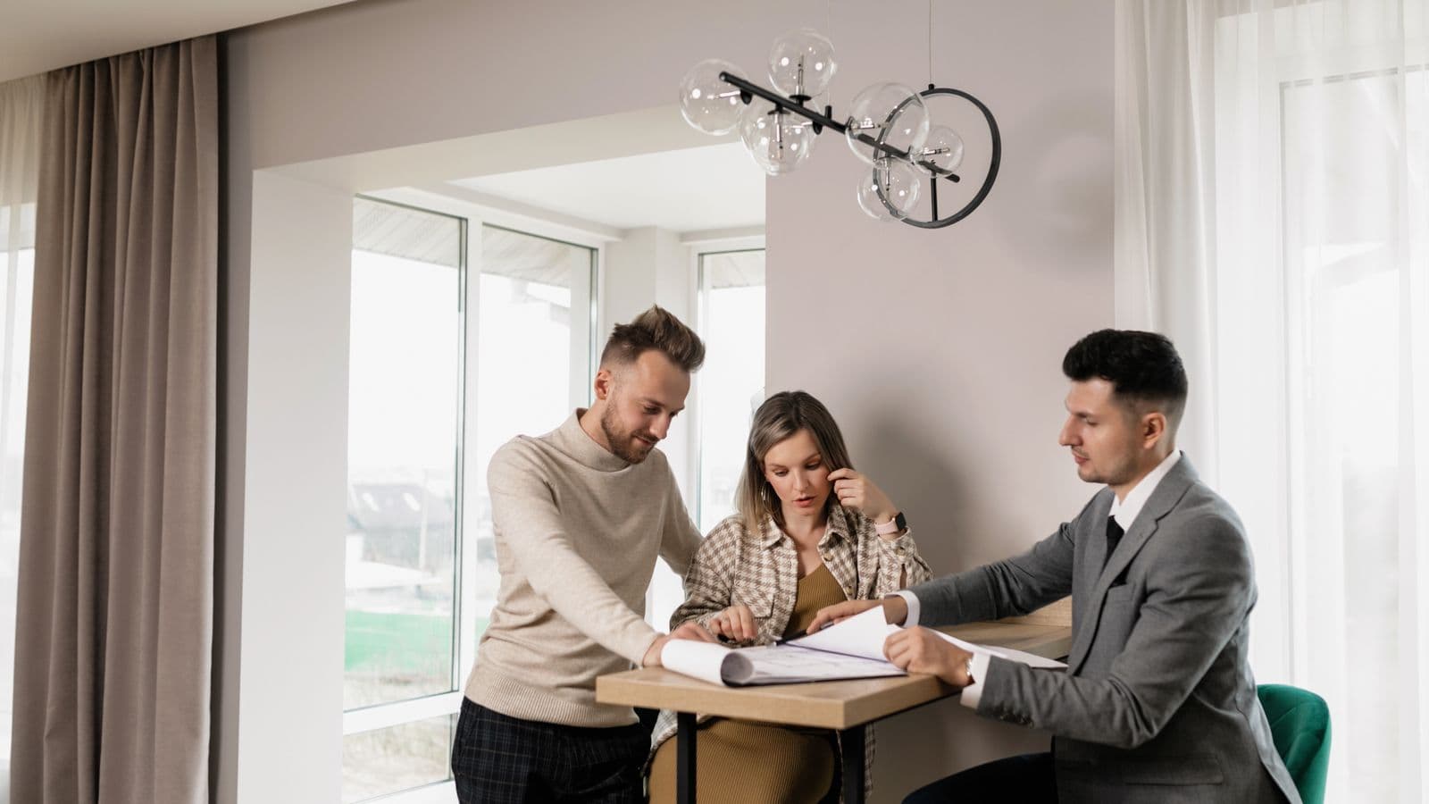 Homeowners reviewing a purchase offer with a home buyer at a table